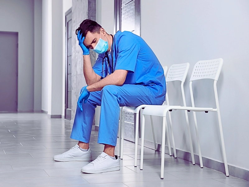 medical professional sitting on a chair in a hallway