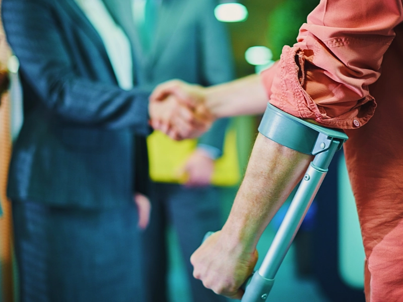 A man with a personal injury shaking hands with a female lawyer.