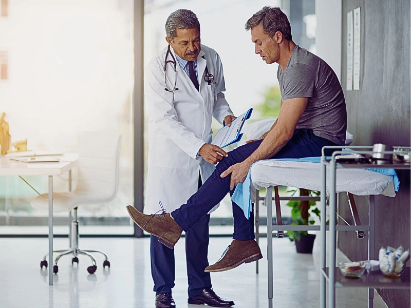 Doctor examining his patient who is concerned about his knee.
