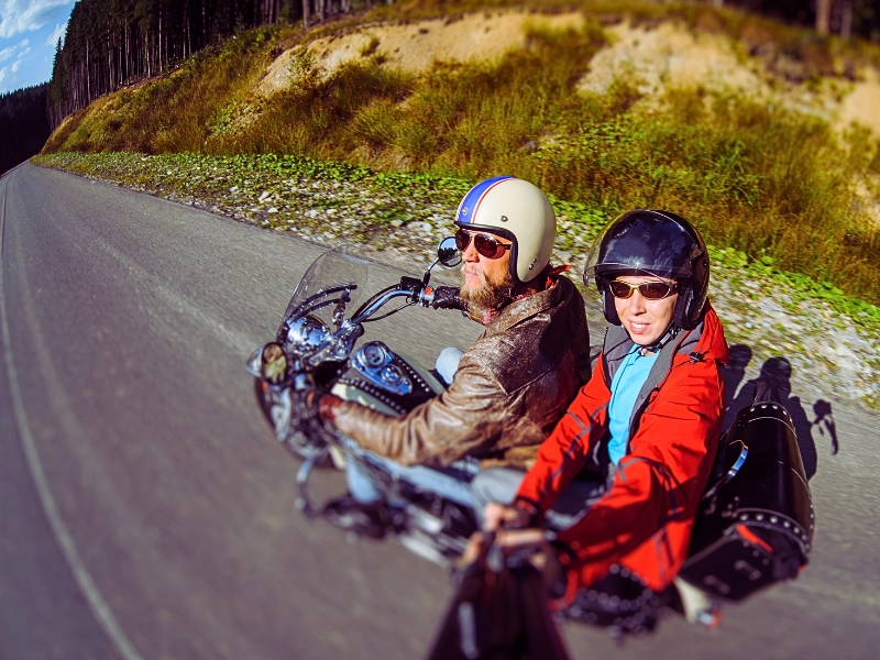Man biker riding his motorcycle on the road with the passenger.