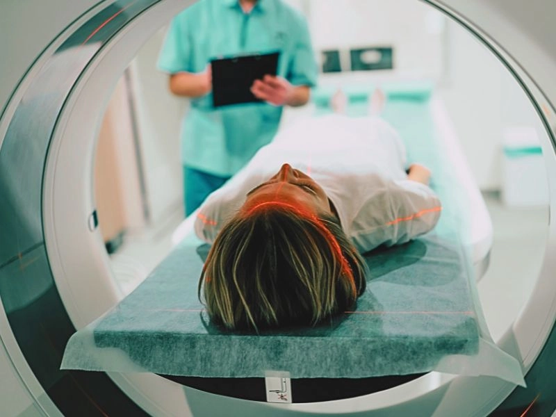 Young woman patient is ready to do magnetic resonance imaging in the modern hospital laboratory.