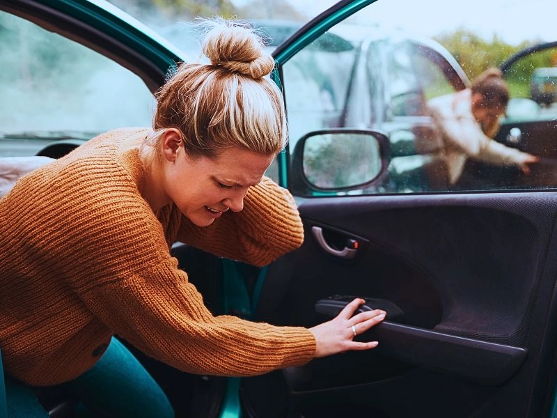 Female Motorist In Crash For Crash Insurance Fraud Getting Out Of Car.