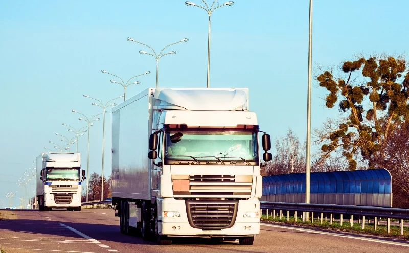 Hit by a Commercial Vehicle in Naperville? How Trucking Company Liability Works 1 Arriving red truck on the road in a rural landscape at sunset. Hit by a Commercial Vehicle