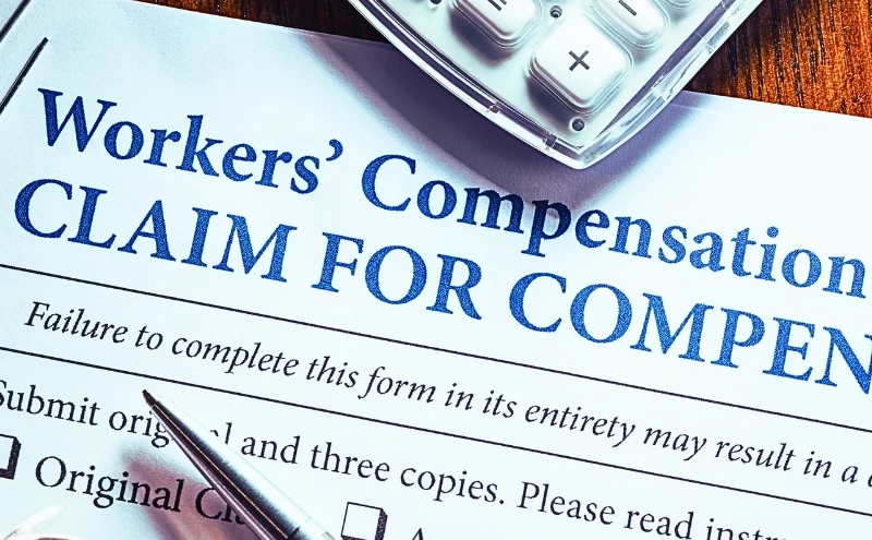 Retaliation for Filing a Workers’ Comp Claim? 1 Workers' Compensation form with pen and glasses. retaliation for filing a workers' comp claim