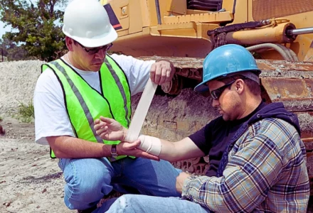 Construction worker wrapping a fellow co-workers arm. third-party liability