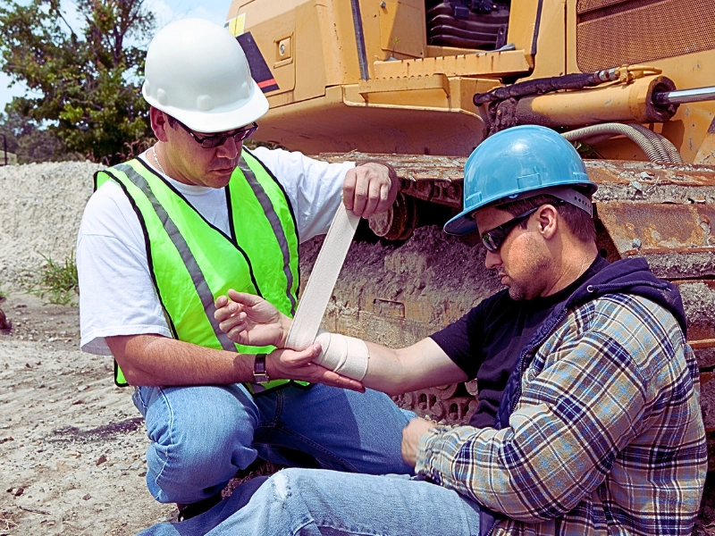 Construction worker wrapping a fellow co-workers arm. third-party liability