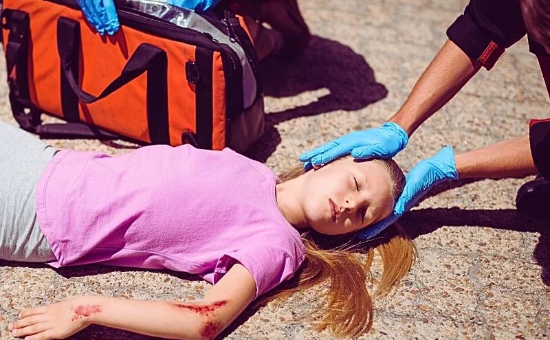 What If Your Child Is Injured in a Car Accident in Illinois? 1 Paramedics examining injured girl on street. Your Child Is Injured in a Car Accident