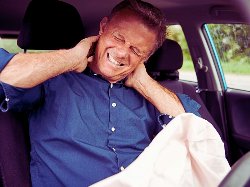 Male Motorist With Whiplash Injury In Car Crash With Airbag Deployed. Car Accidents While On the Job