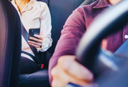 Phone in car or taxi. Passenger woman using cellphone in back seat of cab.