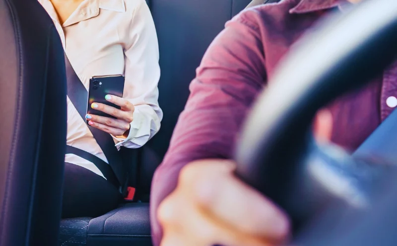 Do Passengers Have the Right to Sue After a Car Accident in Illinois? 1 Phone in car or taxi. Passenger woman using cellphone in back seat of cab.