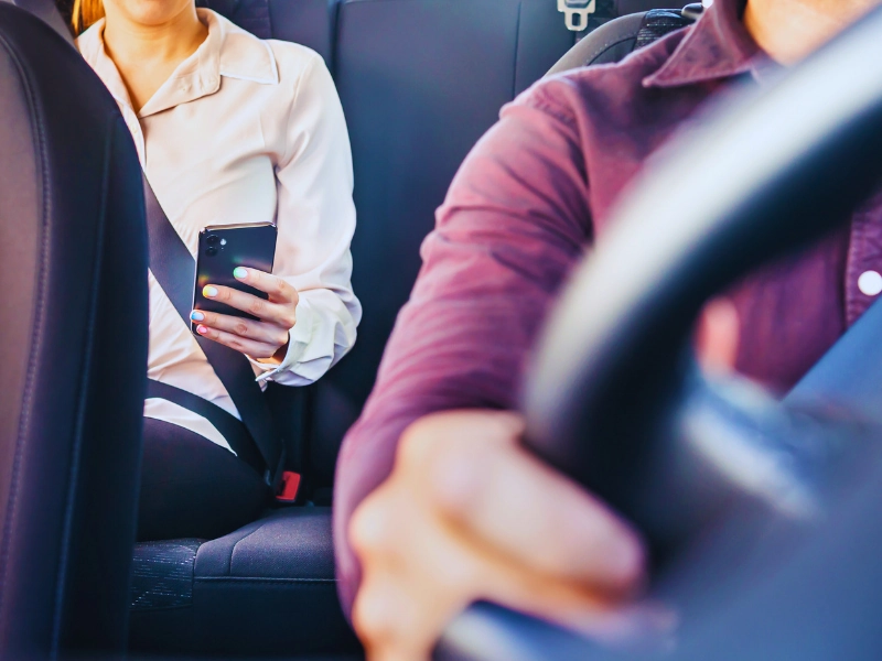 Phone in car or taxi. Passenger woman using cellphone in back seat of cab.