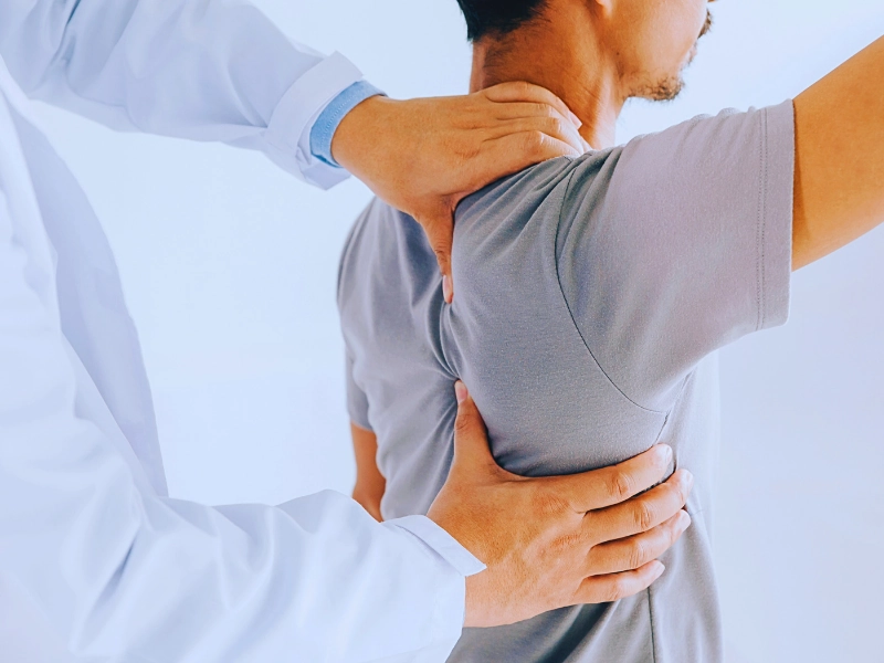 Physiotherapist doing healing treatment on man's back. Independent Medical Exams