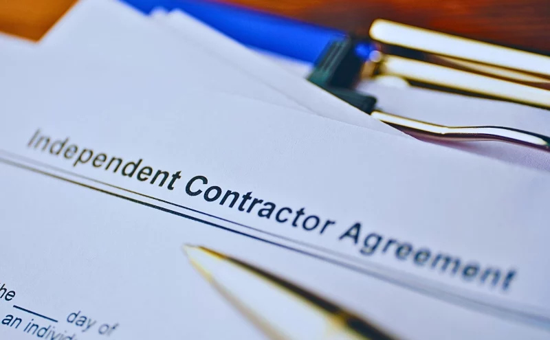 Why Your Naperville Employer Might Try to Misclassify You as an Independent Contractor 1 Legal document Independent Contractor Agreement on paper close up. Misclassify You as an Independent Contractor