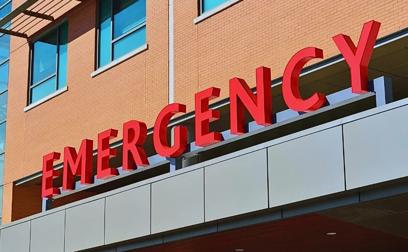 The Portillo’s Tragedy: When Does a Chicago Business Have a Duty to Install Safety Barriers? 1 The word "EMERGENCY" in large, bold red letters mounted on the exterior of a building, likely indicating the entrance to an emergency department of a hospital or medical facility.