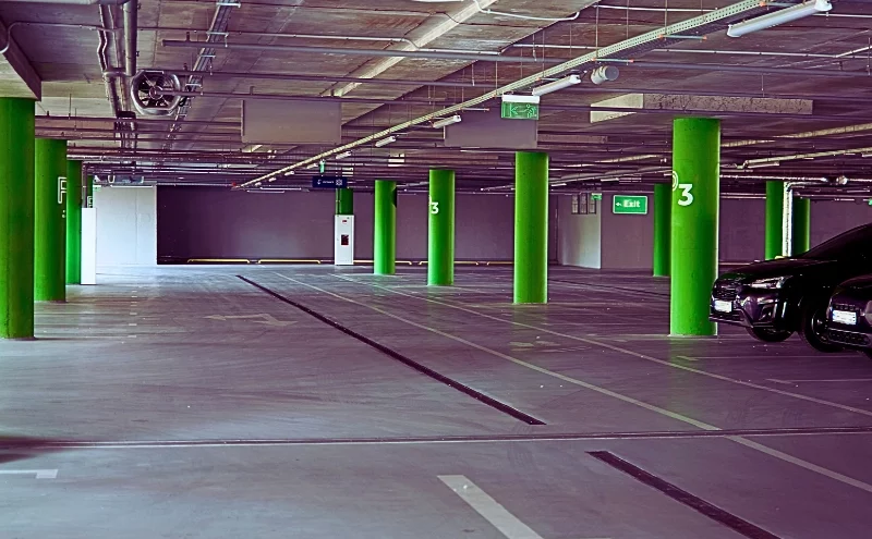 Hit by a Car in a Naperville Parking Lot? What to Know About Your Rights and Compensation 1 an underground parking garage with overhead lights and exit signs hanging from the ceiling. Hit by a Car in a Naperville Parking Lot