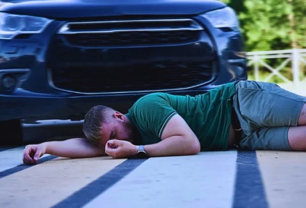 A young man lying on a pedestrian crosswalk after being hit by a dark-colored SUV. How Poor Visibility Affects Injury Claims