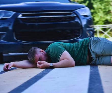 A young man lying on a pedestrian crosswalk after being hit by a dark-colored SUV. How Poor Visibility Affects Injury Claims