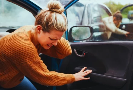 Woman holding her neck in pain while exiting car. Passenger Sue for Injuries
