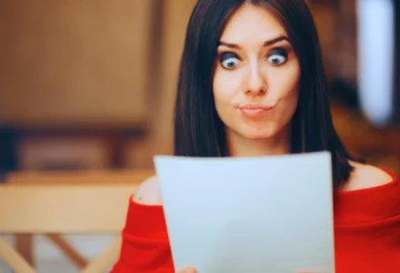 Surprised woman looking at a paper with wide eyes. first settlement offer after a car accident