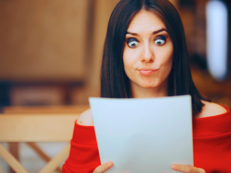 Surprised woman looking at a paper with wide eyes. first settlement offer after a car accident