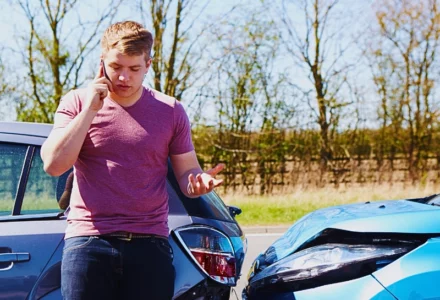Man talking on phone after two-car fender bender. recorded statement to the insurance company
