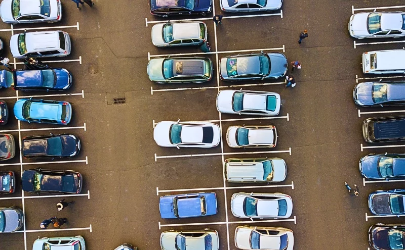 Aerial view of a parking lot filled with parked cars. parking lot pedestrian accidents