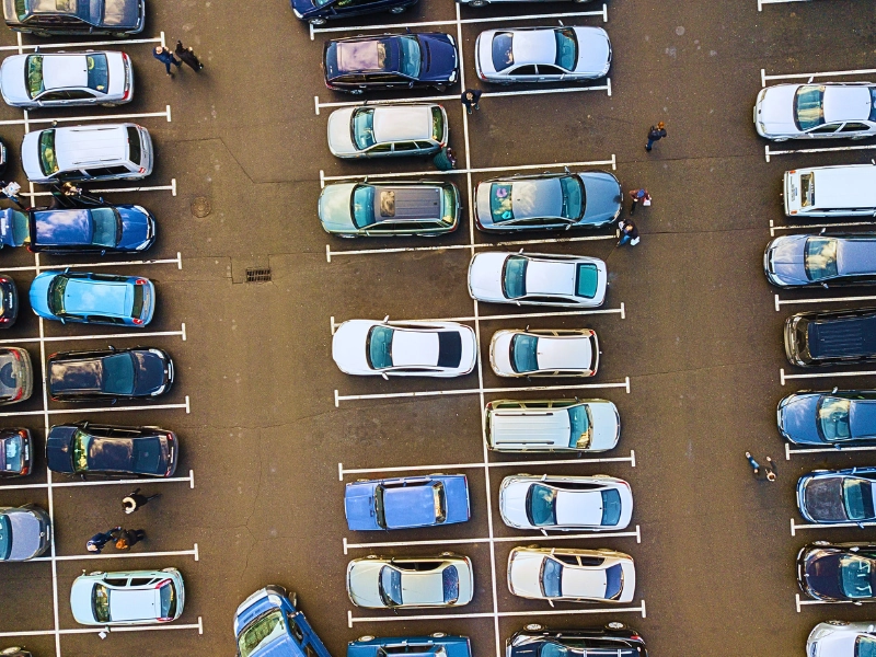 Aerial view of a parking lot filled with parked cars. parking lot pedestrian accidents