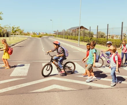 Group of school children crossing the street at a crosswalk.