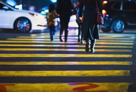 Pedestrians walking across a yellow crosswalk on a city street. downtown Naperville