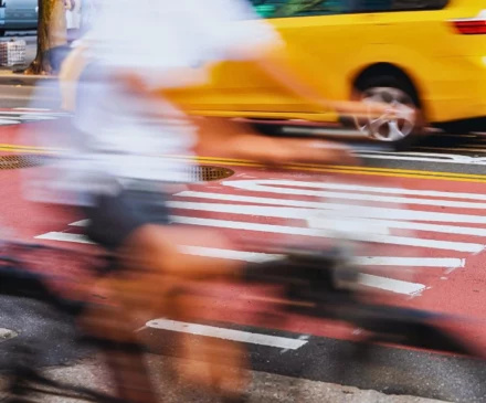 Blurred motion shot of a cyclist riding past a bus.
