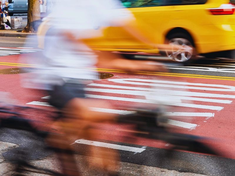 Blurred motion shot of a cyclist riding past a bus.